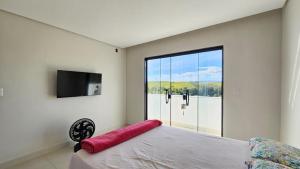 皮拉伊河畔巴拉Casa em Ipiabas的一间卧室，里面有一张床和一扇大窗户。