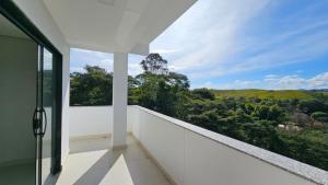 皮拉伊河畔巴拉Casa em Ipiabas的享有乡村美景的白色阳台