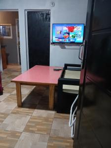 a room with a table and a tv on the wall at Alojamiento B&B Corrientes in Corrientes