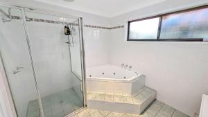 a bathroom with a shower and a bath tub at Collingwood Lodge by Experience Jervis Bay in Vincentia +8 photos