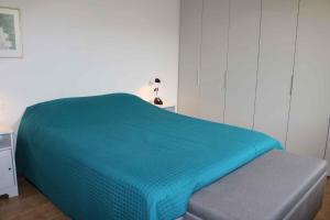 łóżko z niebieską kołdrą w pokoju w obiekcie Studio in Lazise/Gardasee 21938 w mieście Lazise +17 zdjęć