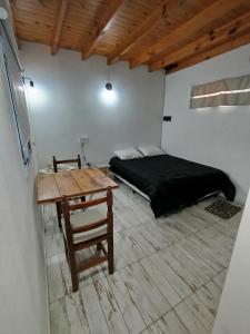 a bedroom with a bed and a table and a desk at La Francisca in San Miguel del Monte