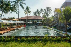 Ấp Long SơnCharm Hon Rom Villas Resort的一个带椅子和棕榈树的度假村游泳池