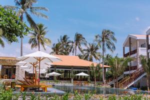 Ấp Long SơnCharm Hon Rom Villas Resort的一个带桌子和遮阳伞的游泳池的度假酒店