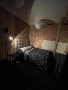 マドリードにあるFamily Master Suite Close By GranViaのベッドとレンガの壁がある寝室 +7枚の写真