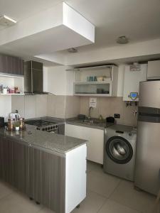 una cucina con lavello e lavatrice di Brisa Patagónica a Comodoro Rivadavia