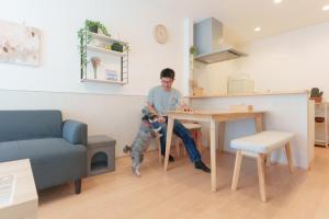 a man sitting at a table with his dog at Habitacion Cottage Suzu in Fujikawaguchiko