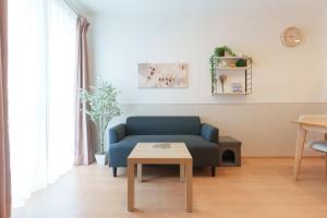 a living room with a blue couch and a table at Habitacion Cottage Suzu in Fujikawaguchiko