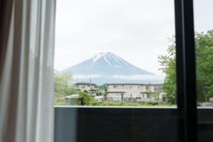Elle offre une vue sur la montagne depuis sa fenêtre. dans l'établissement Habitacion Cottage Suzu, à Fujikawaguchiko