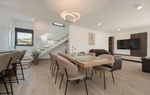 a dining room and living room with a table and chairs at Cozy Home In Turanj With Sauna in Turanj