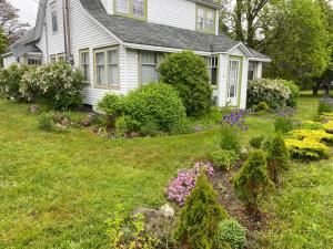 a white house with a garden in the yard at Studio 181 Bed & Breakfast in Port Clyde