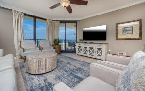 un salon avec un canapé et une télévision dans l'établissement Phoenix X 303 condo, à Orange Beach