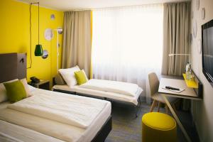 Ein Bett oder Betten in einem Zimmer der Unterkunft Vienna House Easy Günzburg