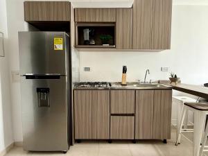 a kitchen with a stainless steel refrigerator and a sink at Acogedor Refugio Céntrico con Parking Privado in Armenia