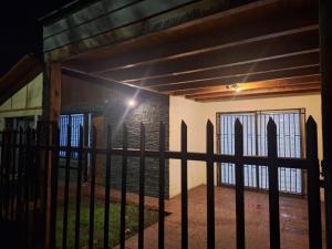a gate in front of a house with windows at Casa Hostal Nora, Rauquén Curicó in Curicó