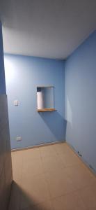 an empty room with a blue wall and a shelf at Carmelo in San Rafael