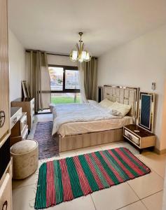 ein Schlafzimmer mit einem Bett und einem großen Fenster in der Unterkunft Marina Marassi - Luxury 3 bd Chalet in El-Alamein