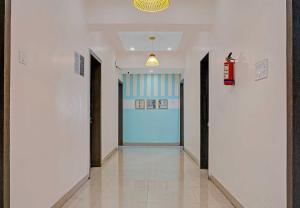 a hallway with a blue door in a building at Super Hotel O Pimpri Stays in Chinchiwad