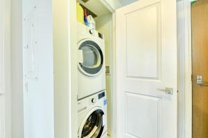 a washer and dryer in a room next to a door at RivetStays - The Jarvis in Toronto