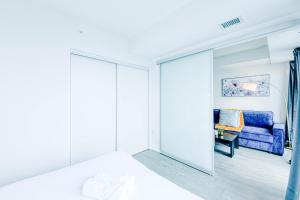 a bedroom with a mirror and a blue couch at RivetStays - The Jarvis in Toronto