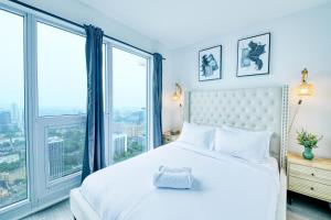 a bedroom with a white bed and large windows at RivetStays - The Jarvis in Toronto