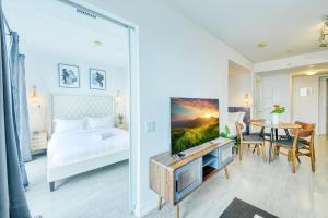 a bedroom with a bed and a table with a tv at RivetStays - The Jarvis in Toronto