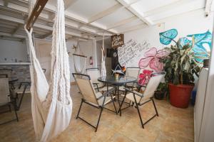 a room with a table and chairs and a wall with graffiti at Suite Studio Manta in Manta
