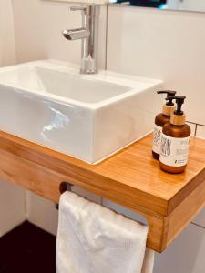 a bathroom sink with two bottles of soap on a wooden counter at Hotel Boutique El Establo in Puerto Natales