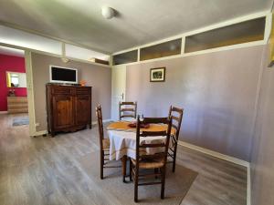 a dining room with a table and chairs and a tv at Apartment in Arromanches near Sandy Beach in Arromanches-les-Bains +10 photos