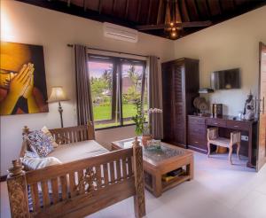 uma sala de estar com um sofá e uma mesa em Solo Villas & Retreat em Ubud