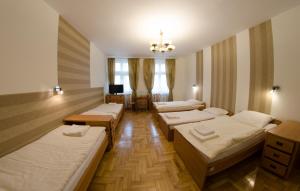 a room with four beds and a television in it at Brama Hostel in Krakow
