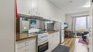 a kitchen with white cabinets and a stove top oven at Alpine Haven 4 in Mount Hotham