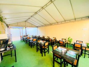 a dining room with tables and chairs in a building at Pousada Vila Mansa Jeri in Jericoacoara