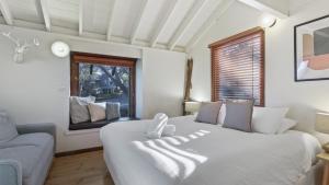 a bedroom with a large white bed and a couch at Alpine Retreat in Dinner Plain