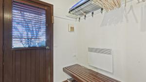 a room with a door and a bench and a window at Alpine Retreat in Dinner Plain +4 photos
