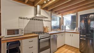 a kitchen with a stove and a microwave at Westons in Dinner Plain +7 photos