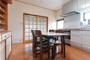 a kitchen with a table and chairs in a room at GuestHouse道 in Fujiyoshida