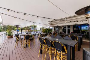 a patio with tables and chairs on a deck at Inala Hotel in Brisbane