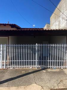 a white fence on the side of a house at Casa Aconchegante Alfenas in Alfenas