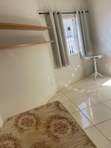 a room with a rug on the floor and a window at Casa Aconchegante Alfenas in Alfenas