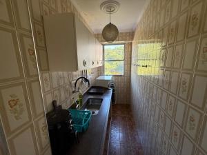 a small kitchen with a sink and a window at Apartamento Vista da Praia Espetacular! in São Vicente