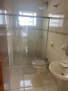 a bathroom with a shower and a toilet and a sink at Casa Aconchegante Alfenas in Alfenas +11 photos
