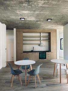 een kamer met 2 tafels en stoelen en een keuken bij Il Buco in Carilo