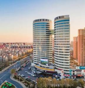 天津Crystal Orange Hotel Tianjin Jinghai Dongfanghong Road的一座城市里有两栋高楼，有一条街道