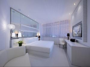 天津Crystal Orange Hotel Tianjin Jinghai Dongfanghong Road的一间白色的卧室，配有一张白色的床和一张书桌