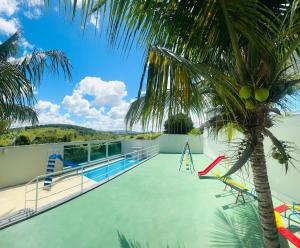 a pool with a palm tree on the roof of a house at Baitinga clube in Amargosa