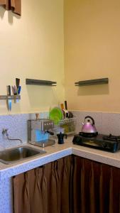 a kitchen counter with a sink and a stove at Rach APT in Kerobokan