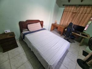 ein Schlafzimmer mit einem Bett und einem Schreibtisch mit einem Laptop in der Unterkunft Habitación para teletrabajo in Santa Cruz de la Sierra