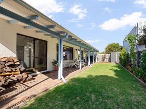 a patio of a house with a grass yard at Villa Maria by the Sea - 500 meters from Prevelly Beach in Prevelly