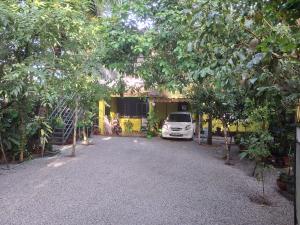 a car parked in front of a house with trees at Greens Homestay Varkala in Varkala
